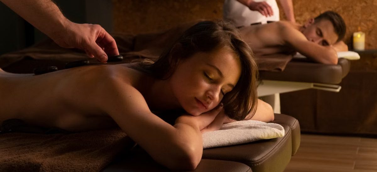 Couple enjoying a relaxing hot stone massage therapy at a spa for rejuvenation and self-care.