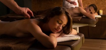 Couple enjoying a relaxing hot stone massage therapy at a spa for rejuvenation and self-care.